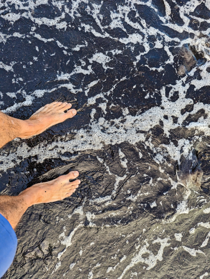 Feet on Black Sand Beach Punlaluu Big Island Hawaii